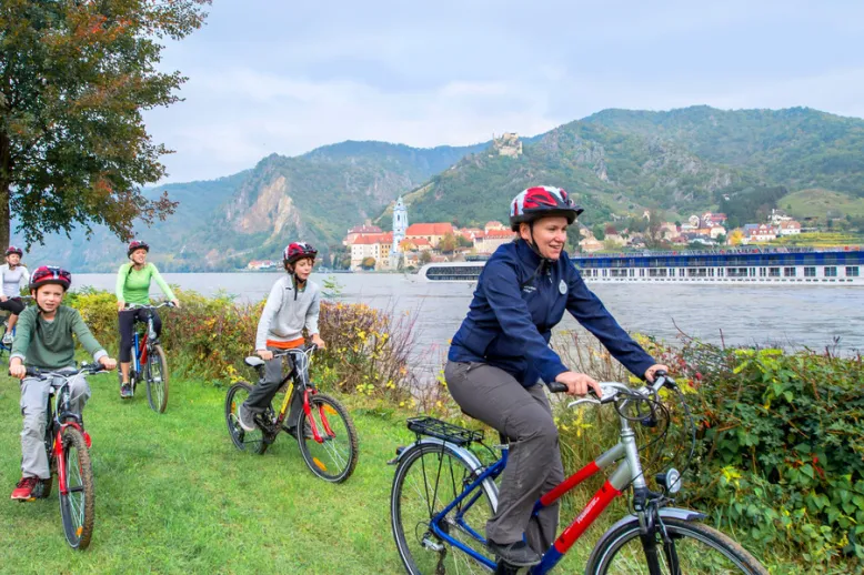 Adventures by disney europe danube river cruise itinerary hero 01 biking next to the danube river1