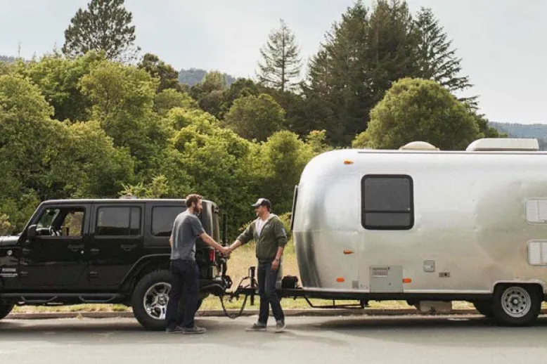 Men handshaking with Jeep and trailer