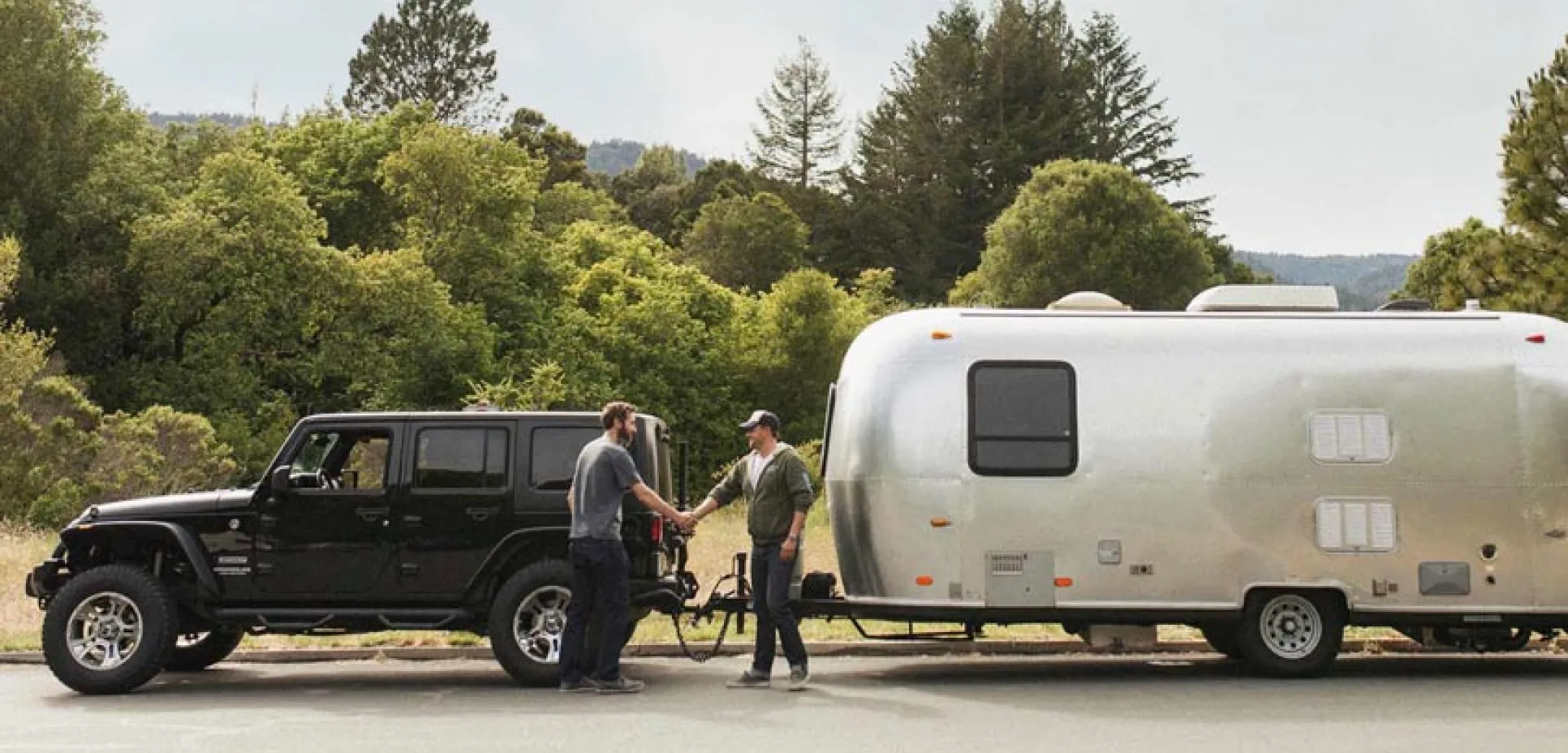 Men handshaking with Jeep and trailer