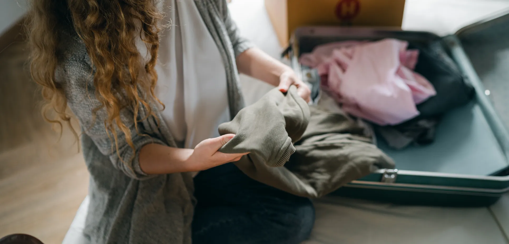 Woman packing suitcase on bed