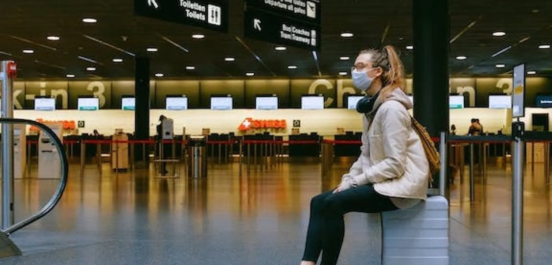 Woman waiting in airport with a mask