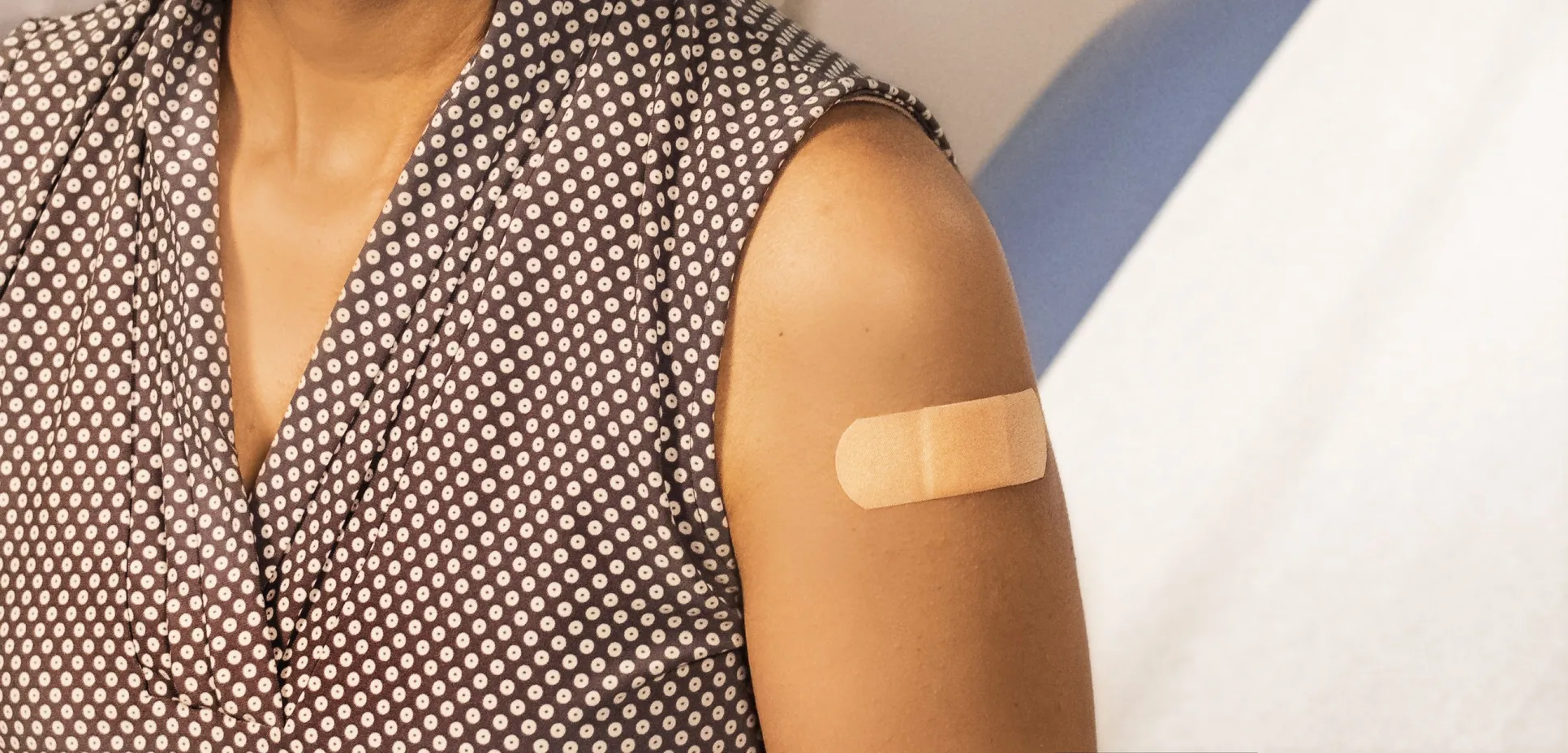Woman with mask and bandaid after getting a vaccine