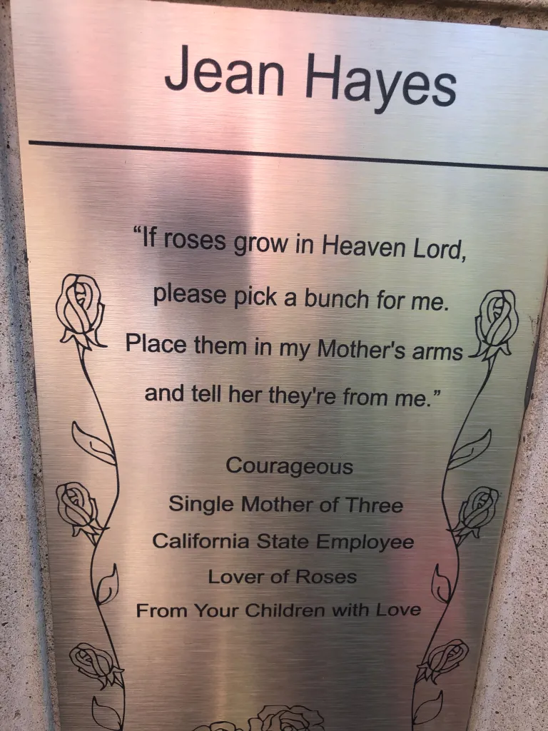A small plaque remembering Travel Guys co-host Mark Hoffmann’s mom can be seen in Capital Park’s Rose Garden