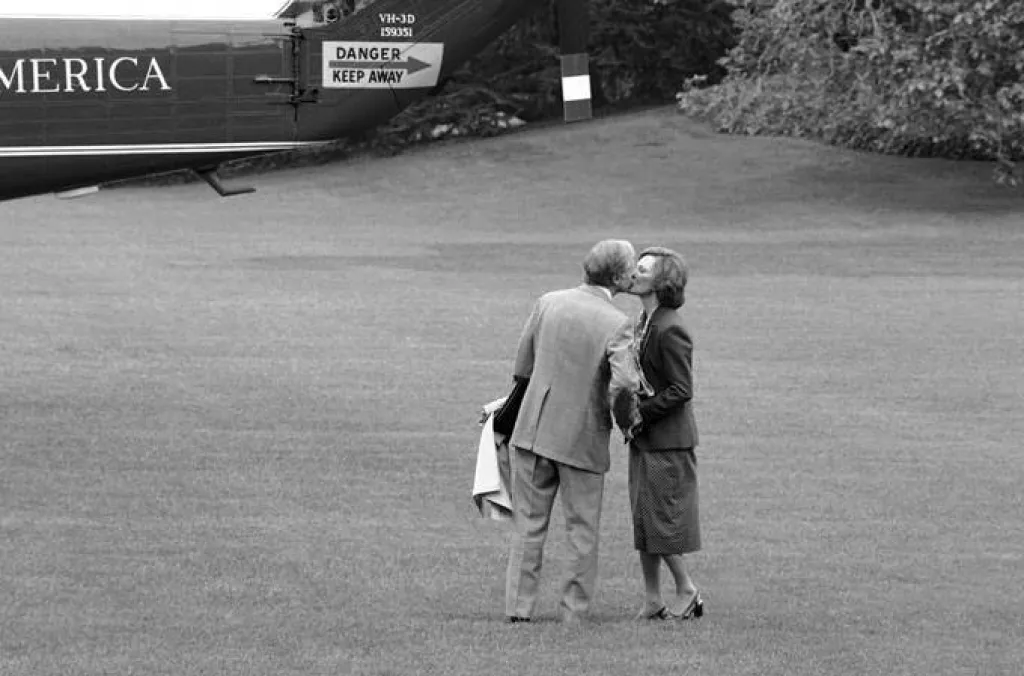 President Jimmy Carter stops to kiss his wife